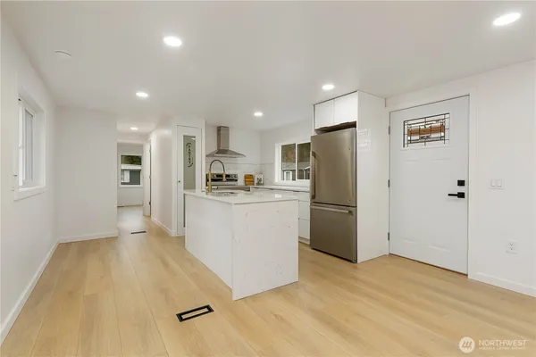 a large kitchen with stainless steel appliances refrigerator sink and cabinets