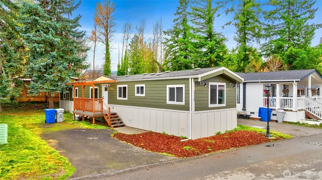 a front view of a house with a yard and trees