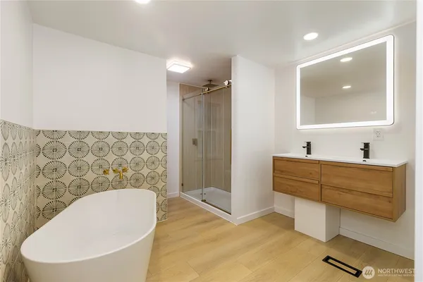 a bathroom with a bathtub sink mirror and toilet