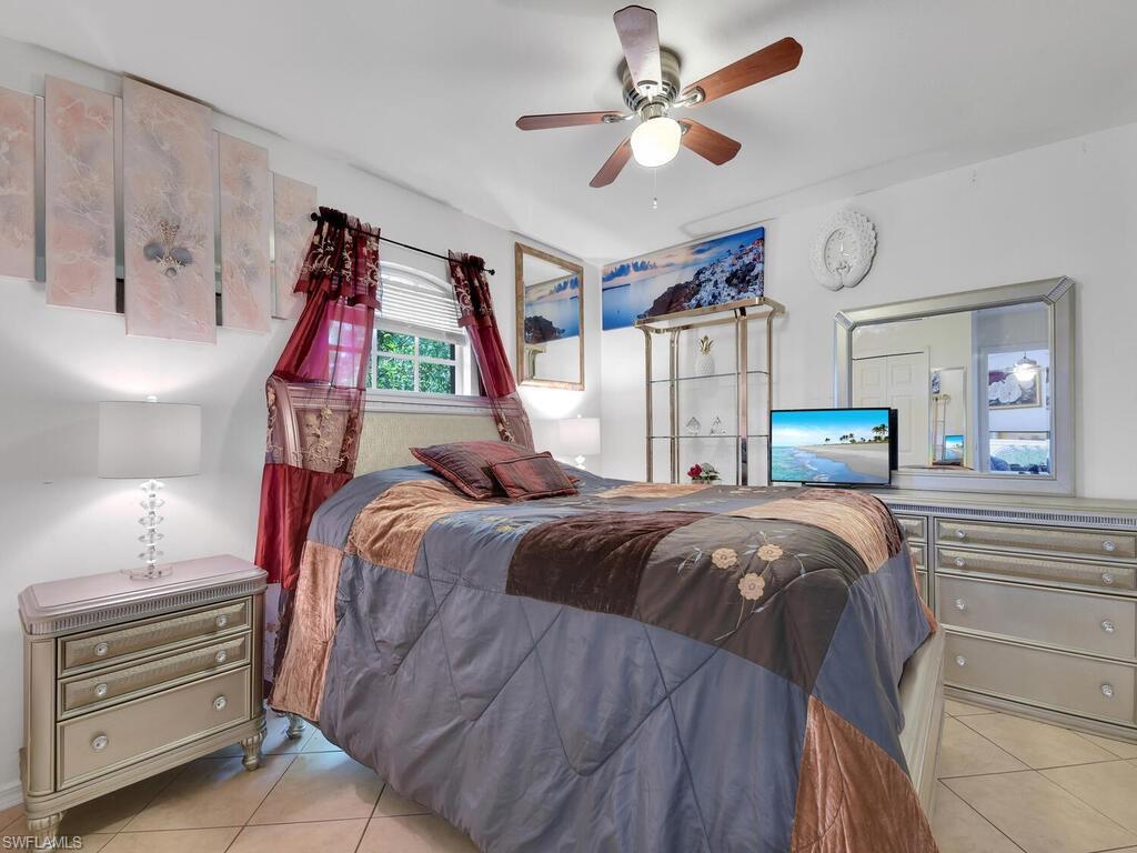 18363 Tulip Road Fort Myers, FL 33967 - Photo 16 of 23 a bedroom with a bed and a chandelier