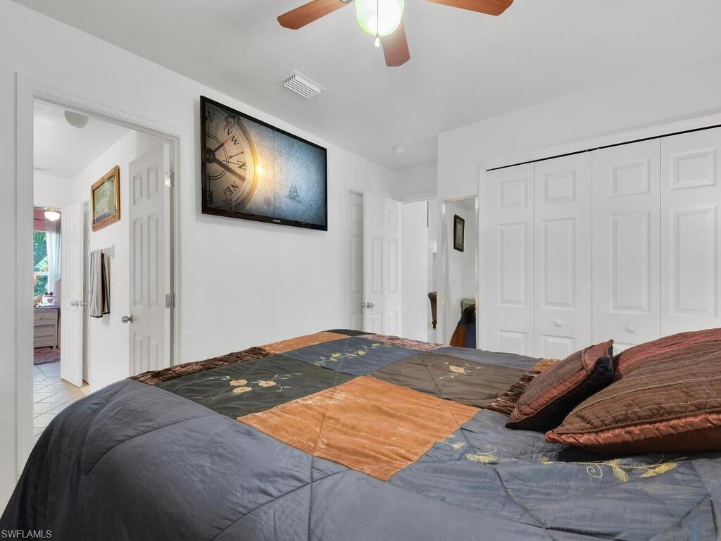 18363 Tulip Road Fort Myers, FL 33967 - Photo 17 of 23 a bedroom with a large bed and a flat screen tv