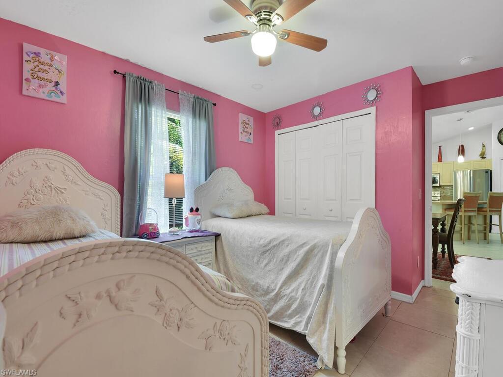18363 Tulip Road Fort Myers, FL 33967 - Photo 19 of 23 a bedroom with a bed and a chandelier