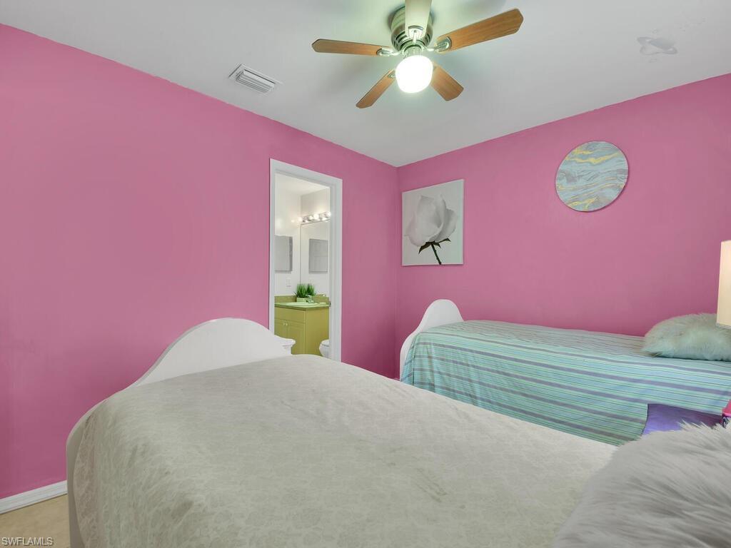 18363 Tulip Road Fort Myers, FL 33967 - Photo 20 of 23 a bedroom with a bed and a chandelier