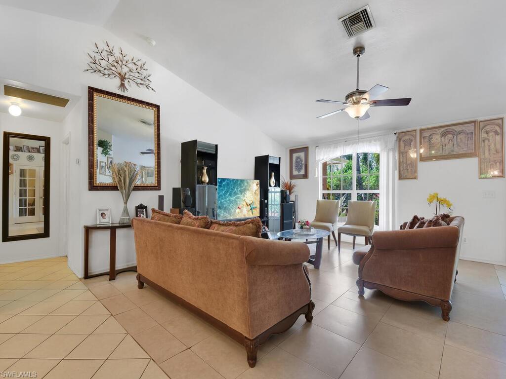 18363 Tulip Road Fort Myers, FL 33967 - Photo 2 of 23 a living room with furniture a flat screen tv and a chandelier