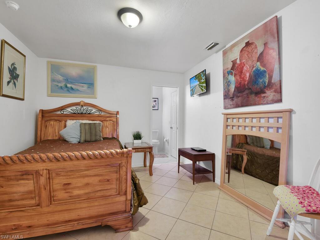 18363 Tulip Road Fort Myers, FL 33967 - Photo 10 of 23 a bedroom with a bed and a fireplace