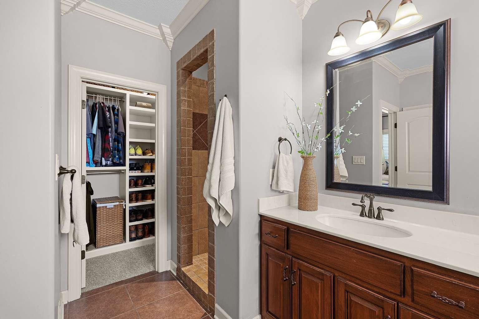 621 Wortham Cemetery Road Bells, TN 38006 - Photo 23 of 25 Bathroom with ornamental molding, a walk in closet, vanity, walk in shower, and dark tile patterned floors