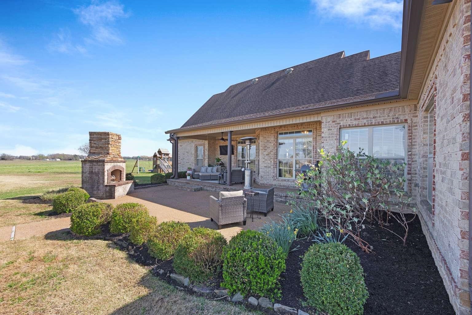 621 Wortham Cemetery Road Bells, TN 38006 - Photo 4 of 25 Back of house featuring brick siding, roof with shingles, an outdoor living space with a fireplace, a patio, and ceiling fan