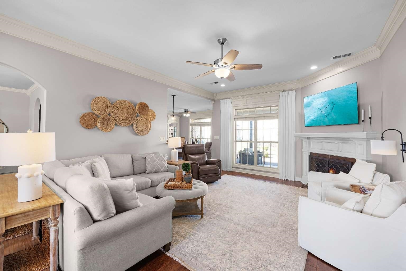 621 Wortham Cemetery Road Bells, TN 38006 - Photo 6 of 25 Living area featuring ornamental molding, wood finished floors, arched walkways, ceiling fan, and a lit fireplace