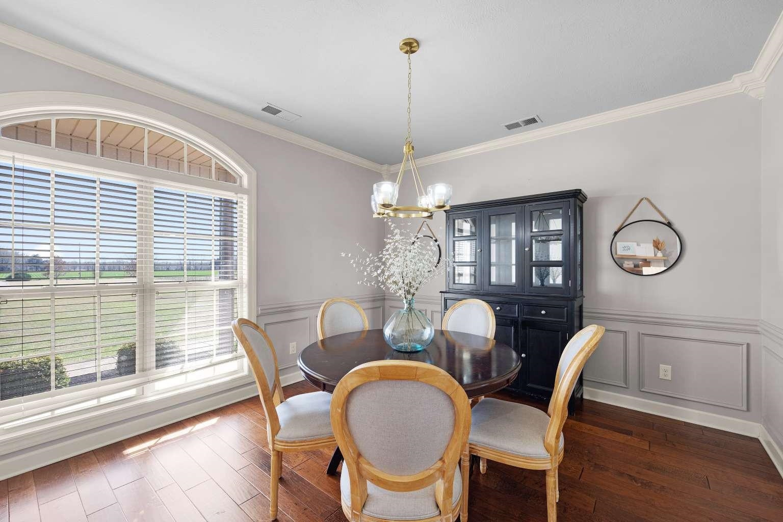 621 Wortham Cemetery Road Bells, TN 38006 - Photo 9 of 25 Dining room with ornamental molding, a chandelier, dark wood-style floors, a wainscoted wall, and a decorative wall