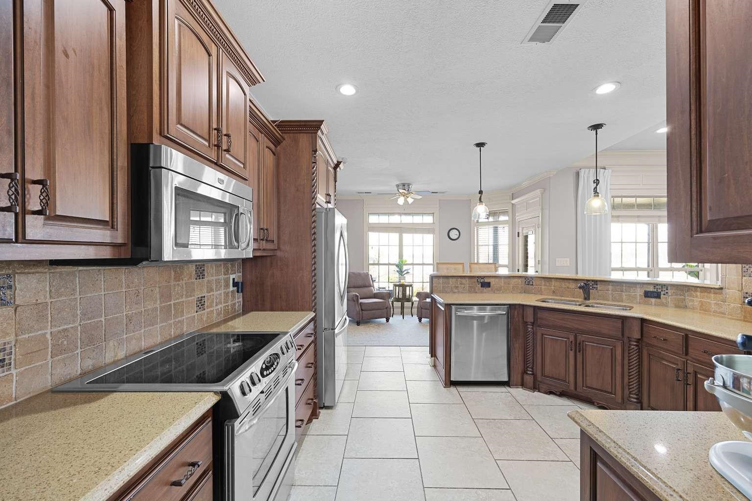 621 Wortham Cemetery Road Bells, TN 38006 - Photo 10 of 25 Kitchen featuring decorative backsplash, stainless steel appliances, light stone counters, ceiling fan, and decorative light fixtures