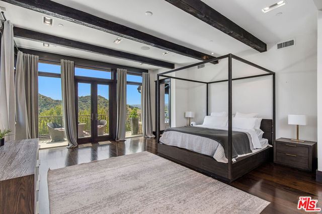 a spacious bedroom with a bed couch and a large window