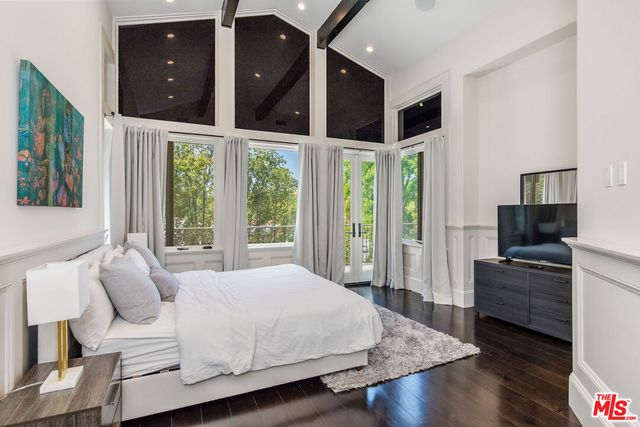 a bedroom with a bed and a flat screen tv