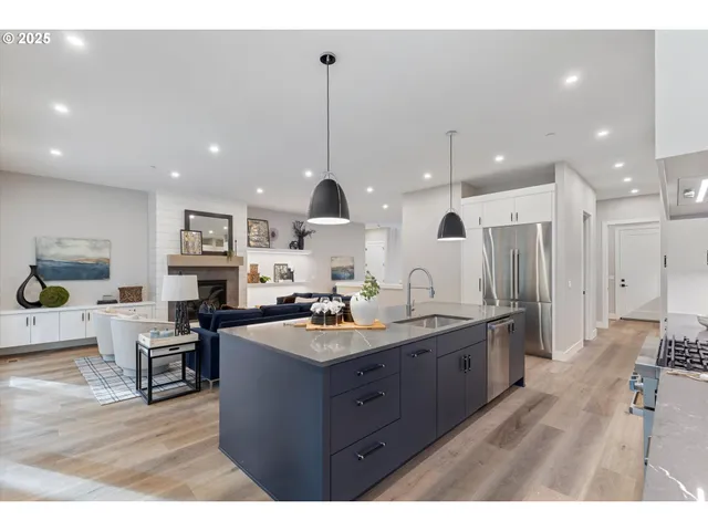 a kitchen with stainless steel appliances granite countertop a sink a stove and a wooden floors