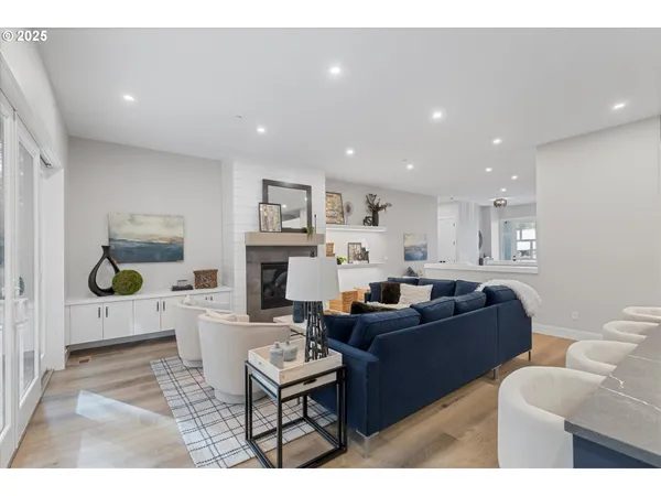 a living room with furniture a fireplace and a kitchen view