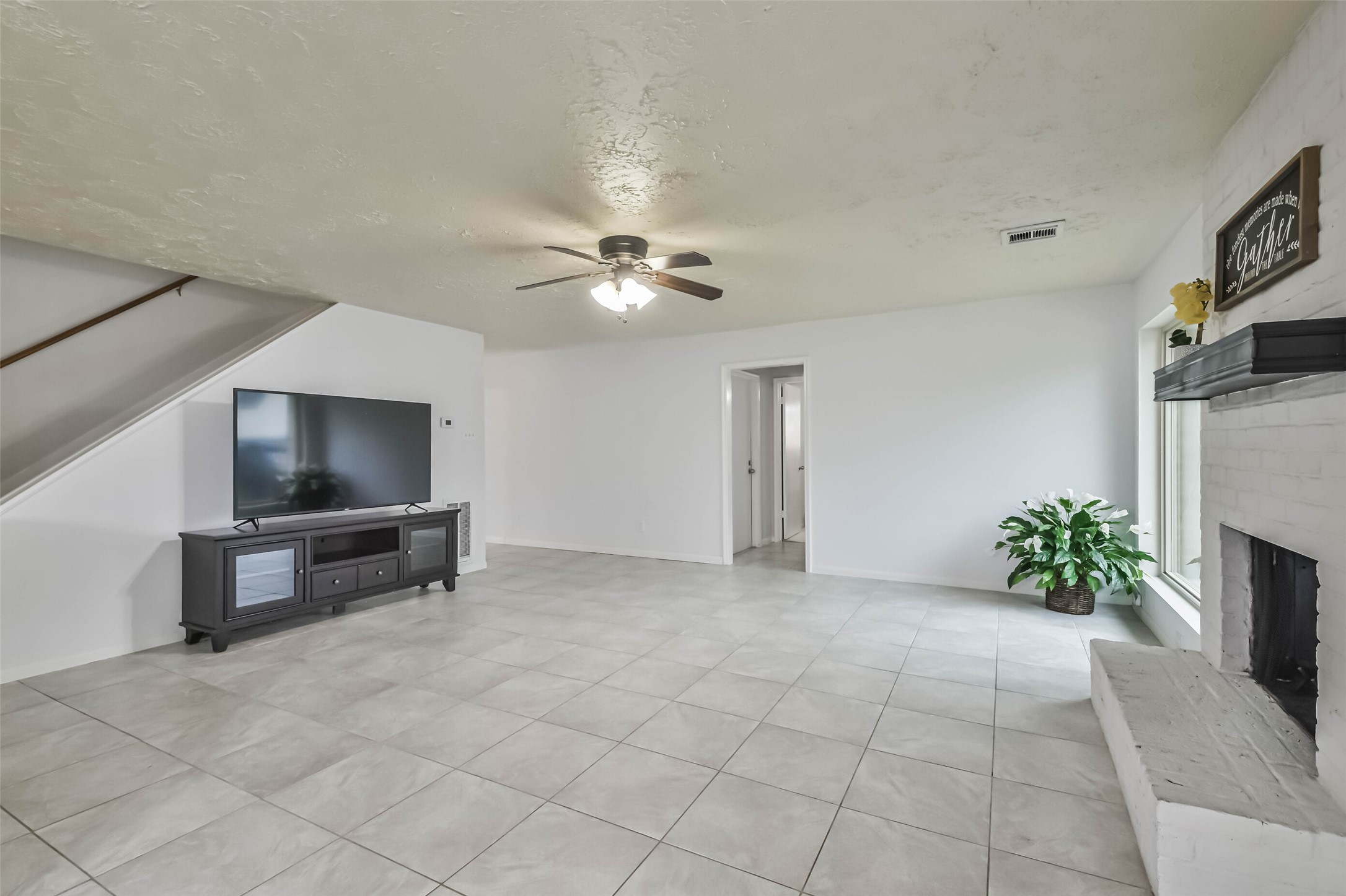 9614 Ballin David Drive Spring, TX 77379 - Photo 11 of 40 a view of an empty room with a fireplace and a chandelier