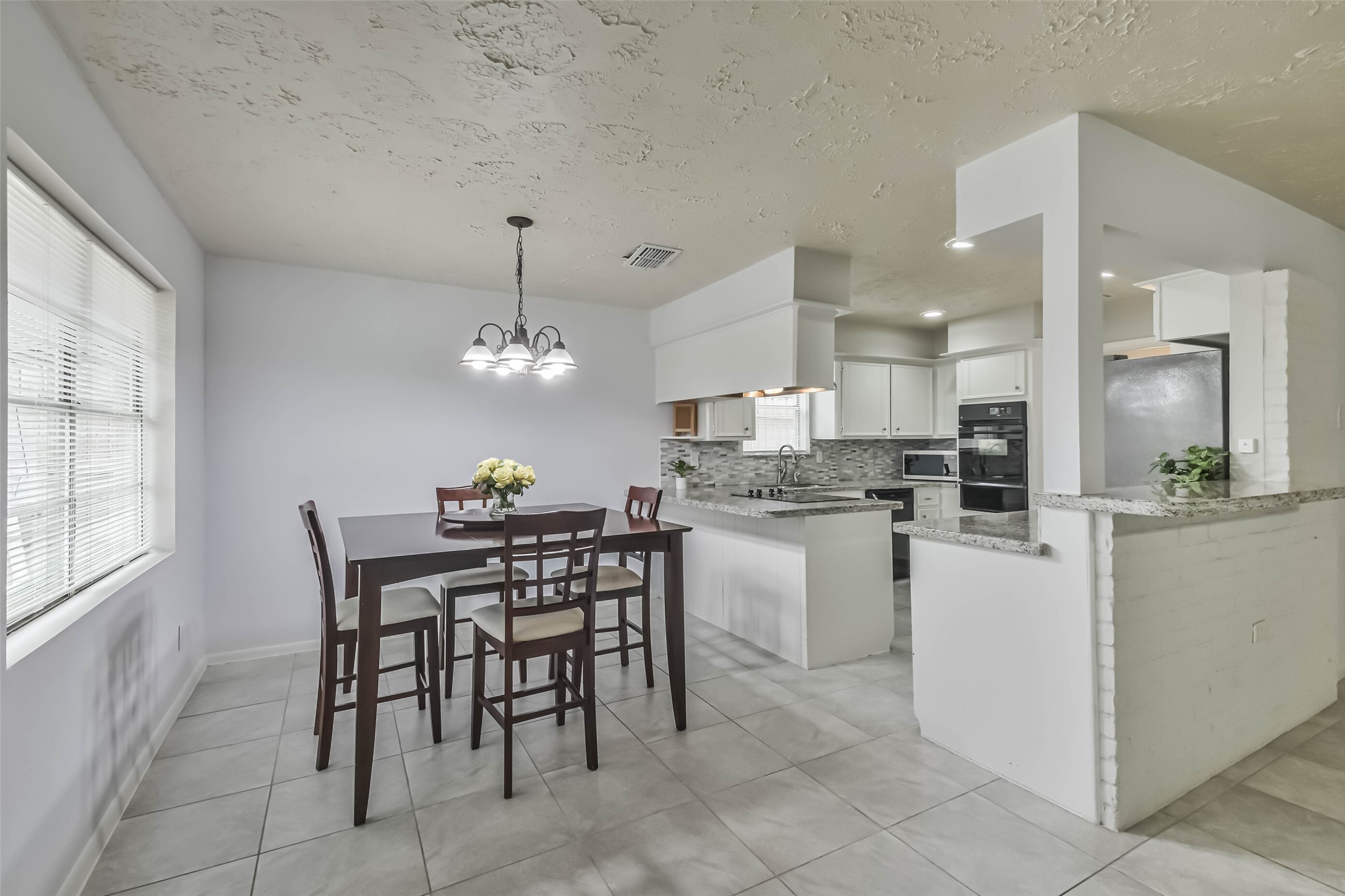 9614 Ballin David Drive Spring, TX 77379 - Photo 13 of 40 a kitchen with a dining table chairs and refrigerator