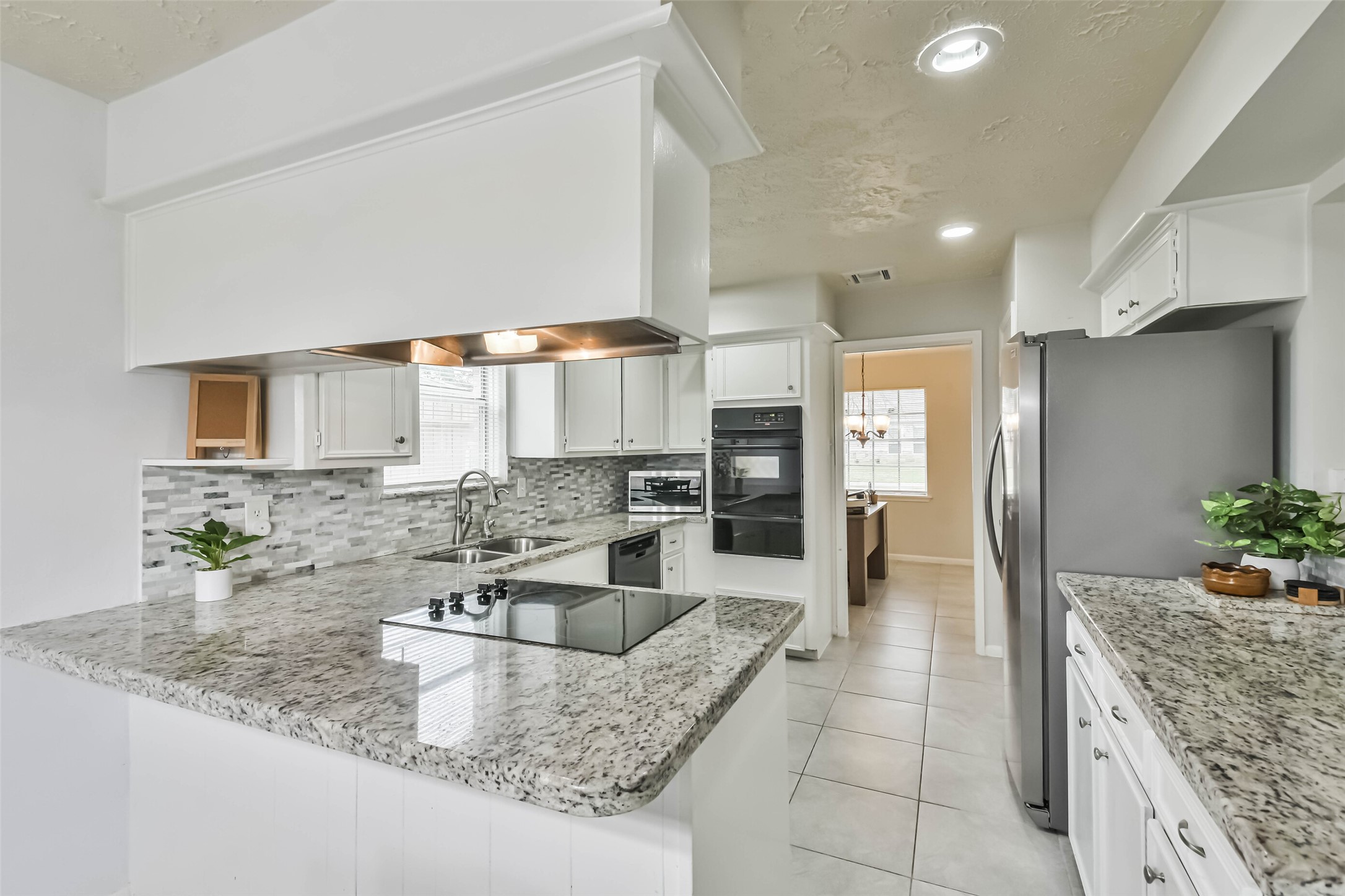9614 Ballin David Drive Spring, TX 77379 - Photo 15 of 40 a kitchen with granite countertop a sink and cabinets