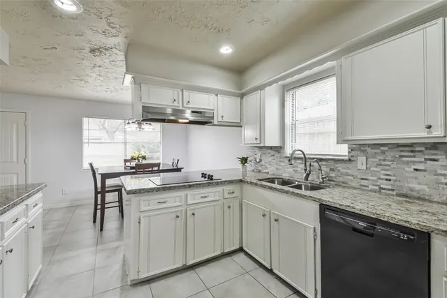 a kitchen with a sink white cabinets and white appliances