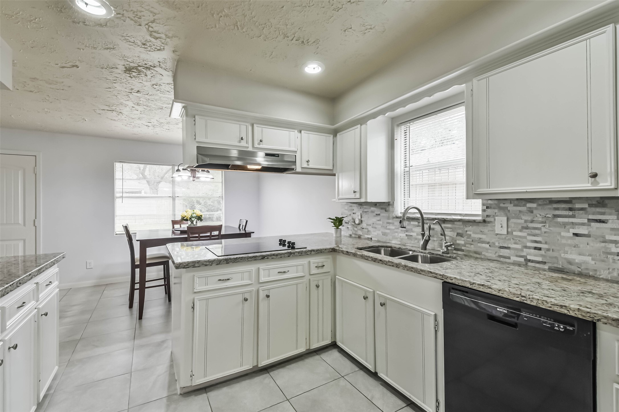 9614 Ballin David Drive Spring, TX 77379 - Photo 17 of 40 a kitchen with a sink white cabinets and white appliances