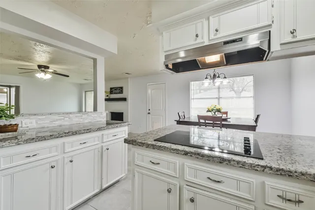 a kitchen with granite countertop white cabinets white appliances and a granite counter tops