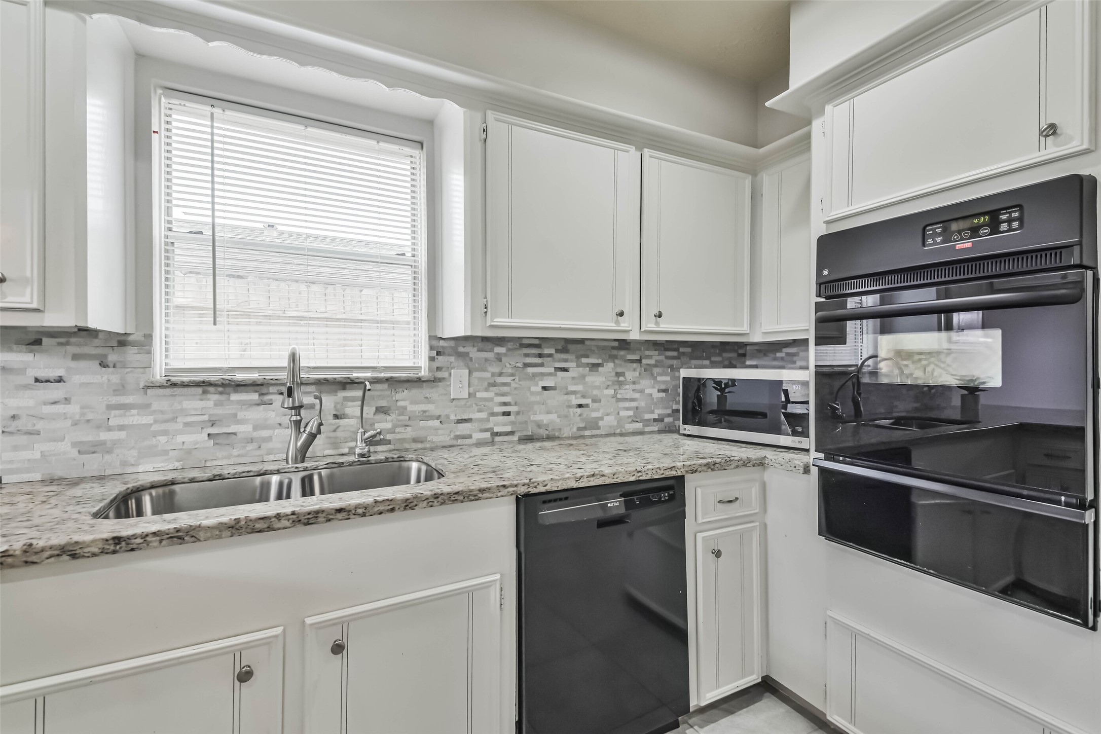 9614 Ballin David Drive Spring, TX 77379 - Photo 19 of 40 a kitchen with stainless steel appliances granite countertop a sink stove and cabinets