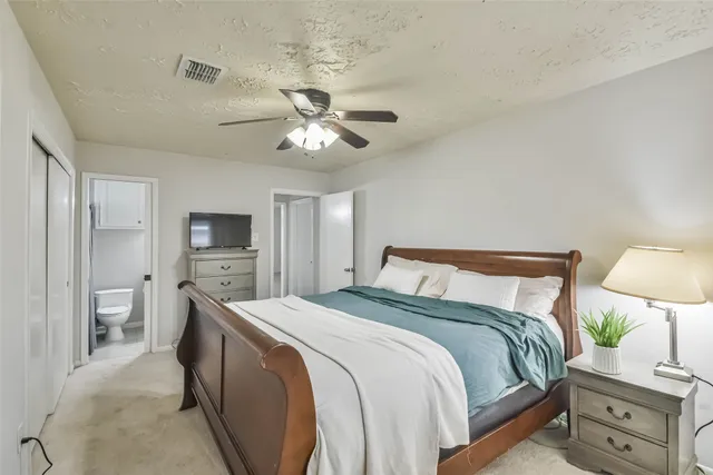 a spacious bedroom with a bed and a tv