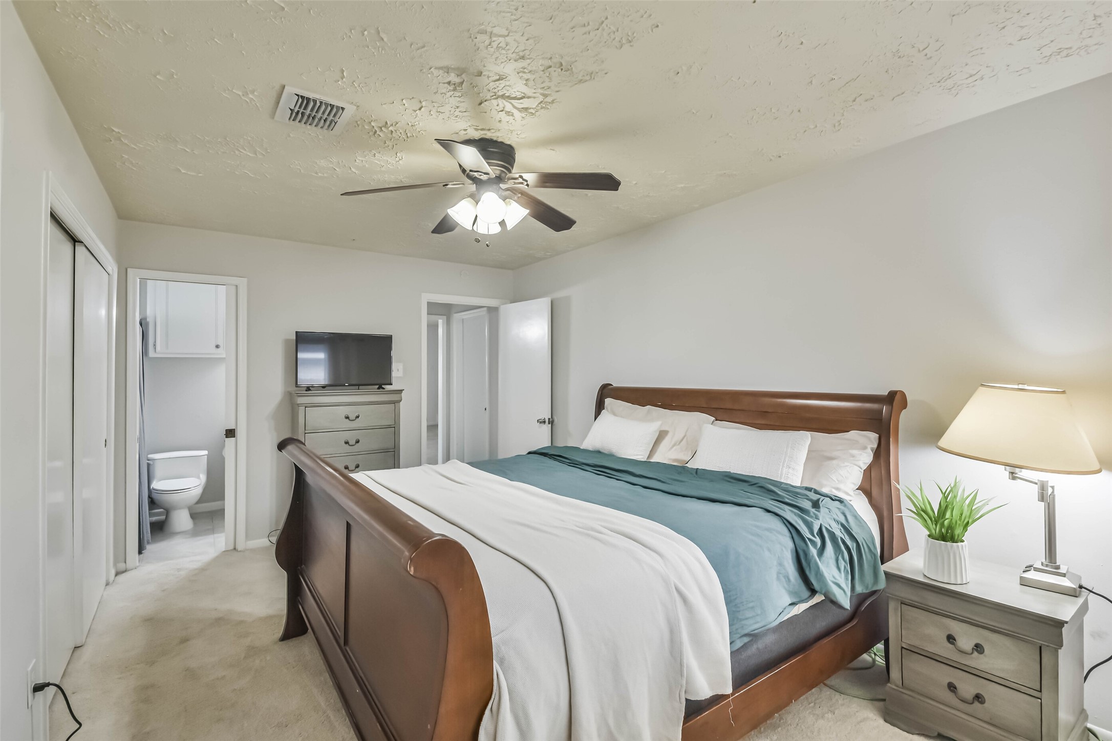 9614 Ballin David Drive Spring, TX 77379 - Photo 22 of 40 a spacious bedroom with a bed and a tv
