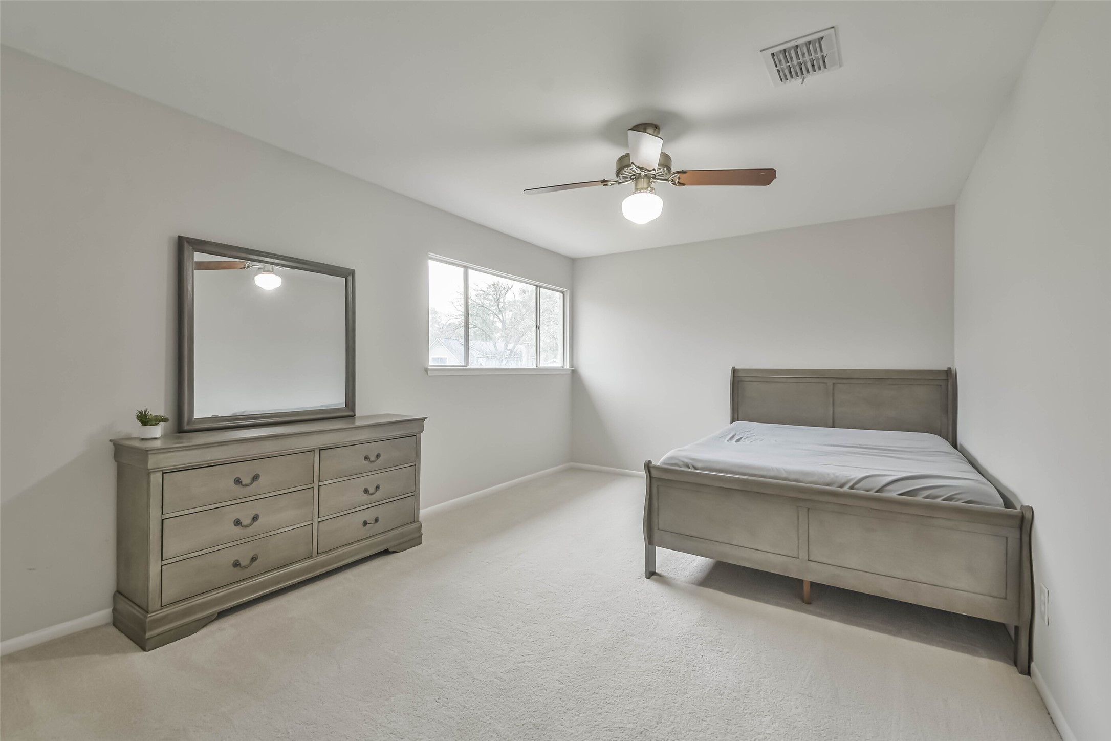 9614 Ballin David Drive Spring, TX 77379 - Photo 27 of 40 a spacious bedroom with a bed and a chandelier