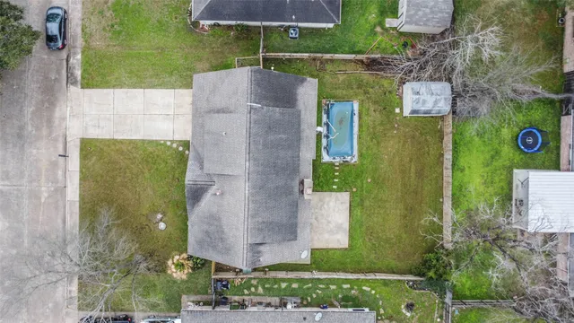 an aerial view of a house with garden space and a swimming pool