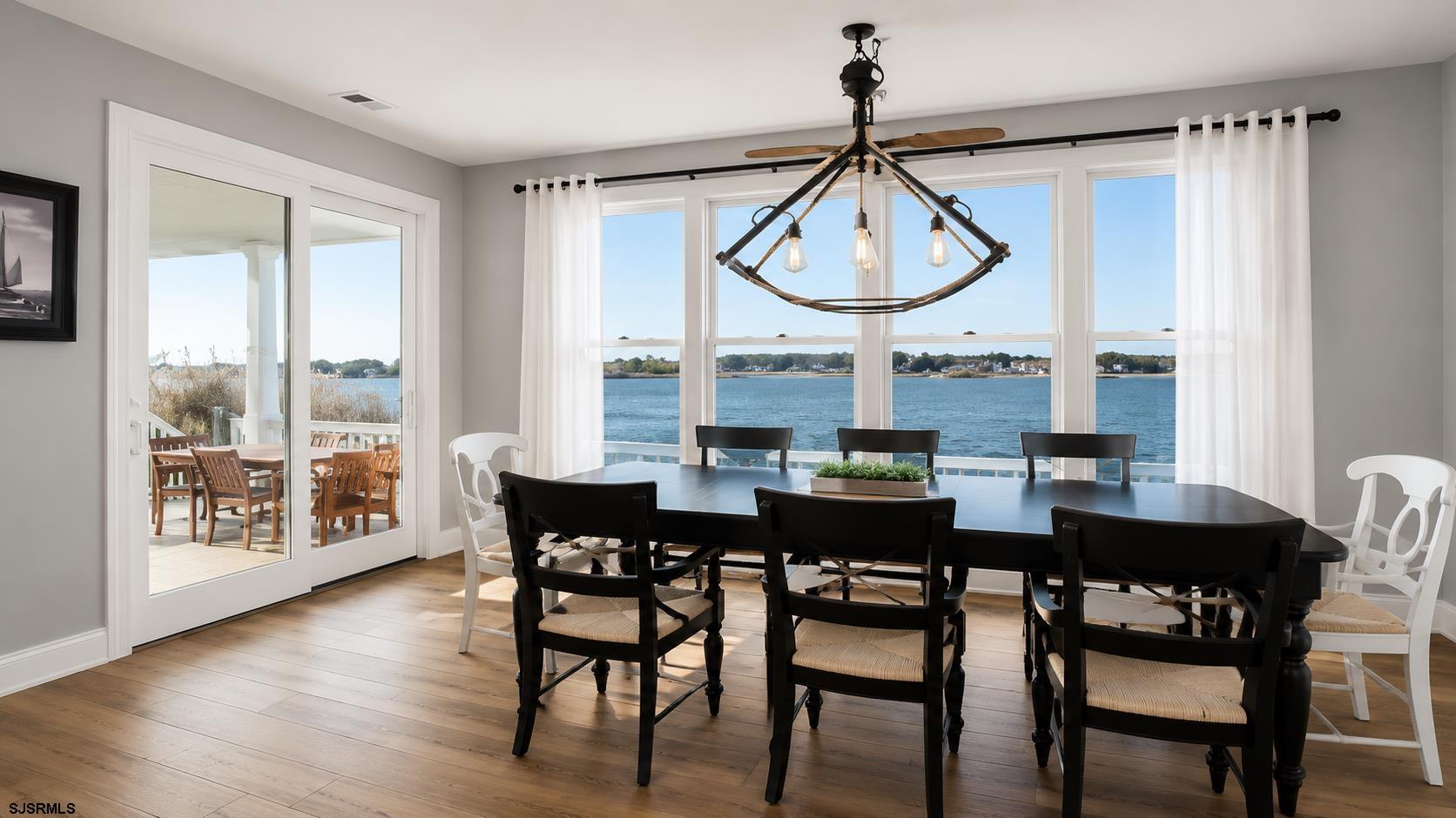 2070 West Riverside Drive Atlantic City, NJ 08401 - Photo 8 of 40 a dining room with wooden floor a chandelier a wooden table and chairs