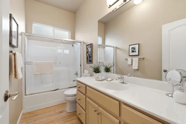 a spacious bedroom with a bed a dresser and a chandelier