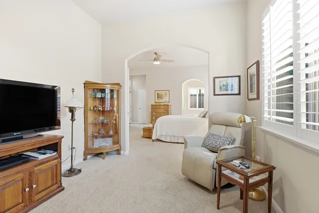 a bathroom with double vanity sinks a large mirror and a bathtub next to a window