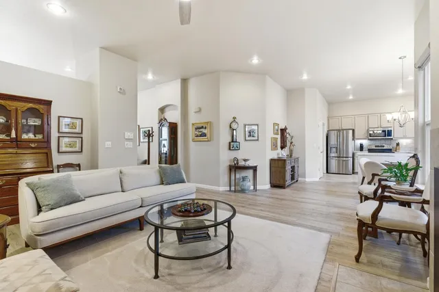 a kitchen with kitchen island a dining table chairs stainless steel appliances and cabinets