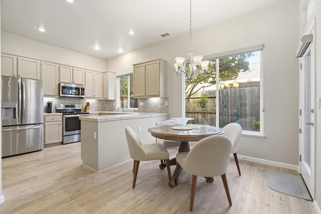 a dining room with furniture a chandelier and wooden floor