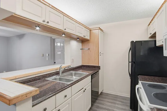 a kitchen with a sink a refrigerator and cabinets