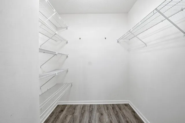 a view of walk in closet with racks on the wall