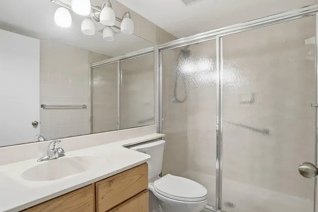a bathroom with a sink toilet a mirror and shower