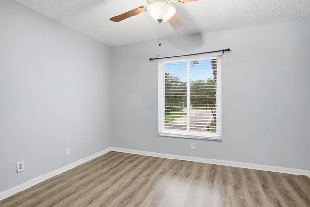 an empty room with a window and wooden floor