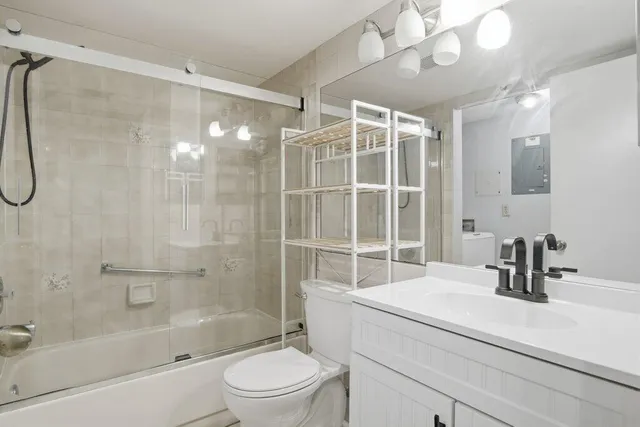a bathroom with a sink a toilet and shower