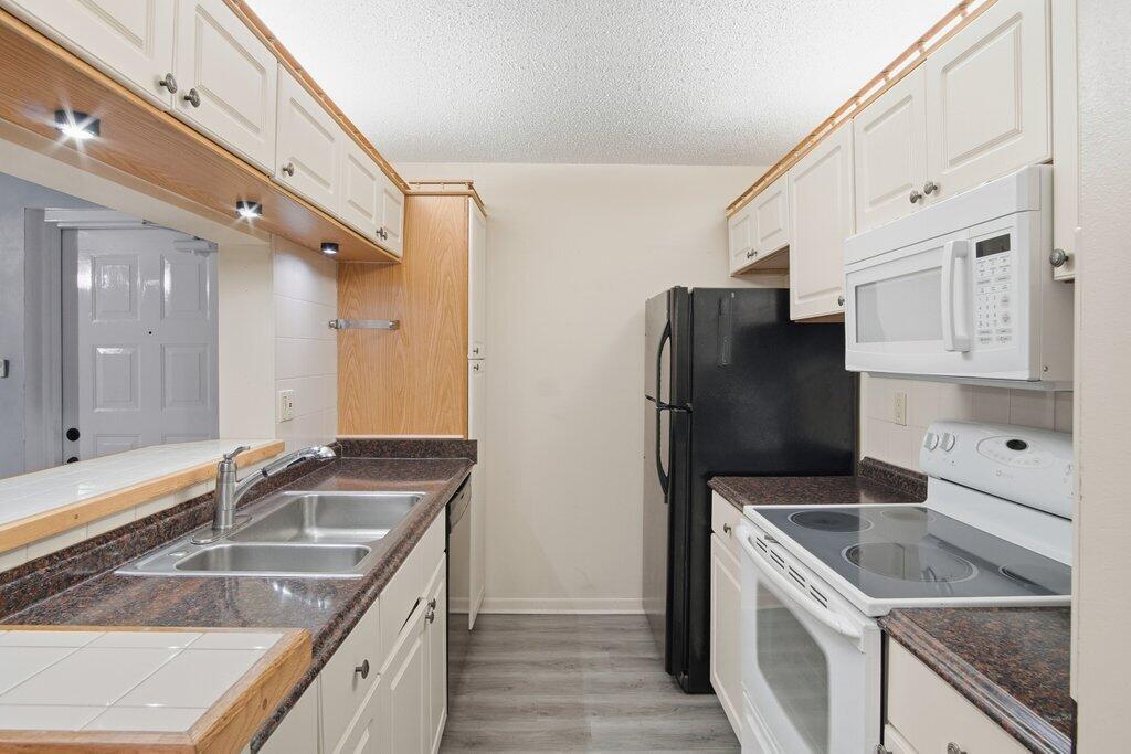 2500 Southeast Anchorage Cove, Unit B2 Port St. Lucie, FL 34952 - Photo 10 of 25 a kitchen that has a sink a stove and a refrigerator