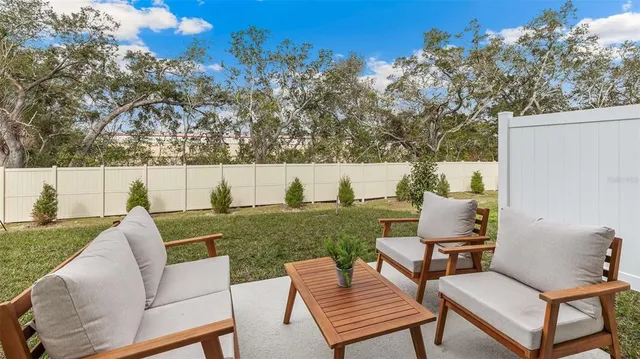 a view of a patio with couches chairs under an umbrella
