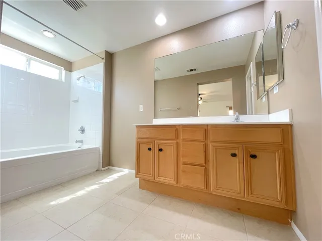 a spacious bathroom with a double vanity sink a mirror and a bathtub