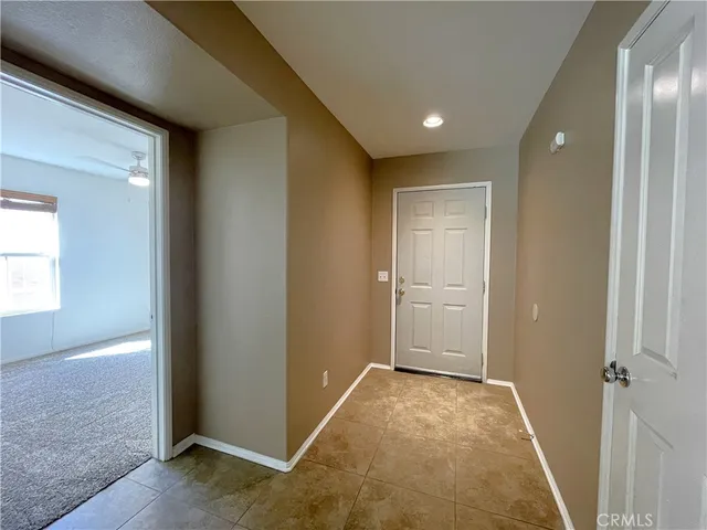 an empty room with wooden floor & windows