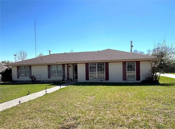 a view of a house with a yard and large tree