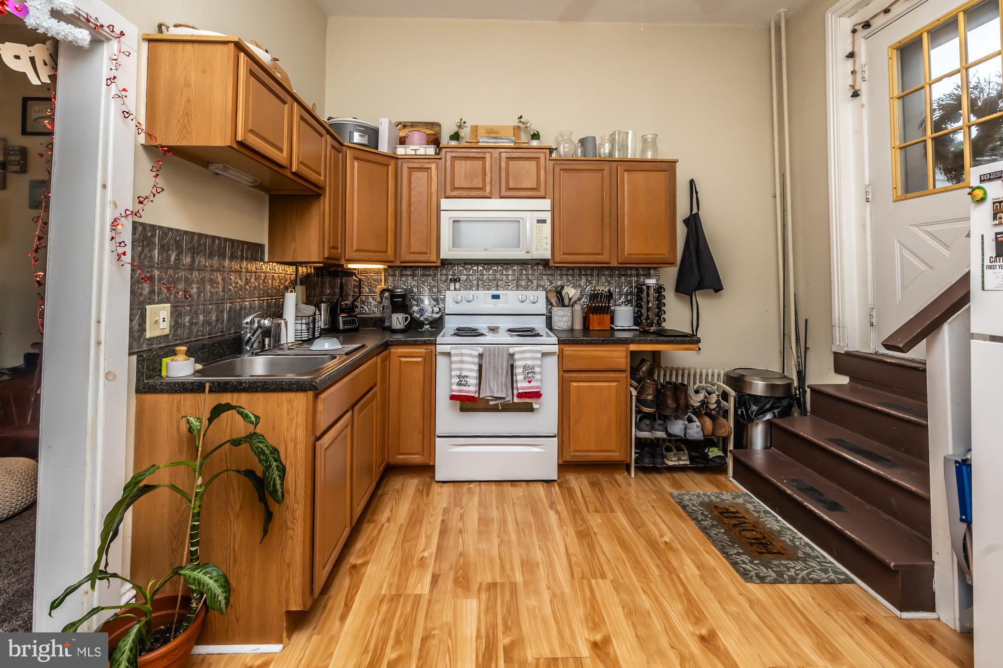 107 West State Street Kennett Square, PA 19348 - Photo 37 of 52 a kitchen with stainless steel appliances granite countertop a stove a sink dishwasher and cabinets with wooden floor