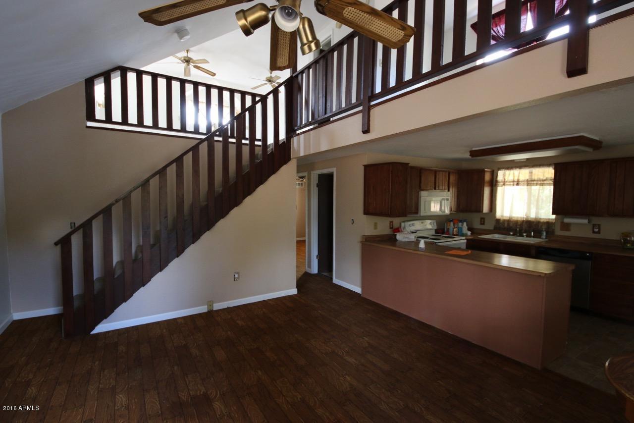3070 Aspen Road Overgaard, AZ 85933 - Photo 24 of 38 a view of living room kitchen with wooden floor and pendant lights