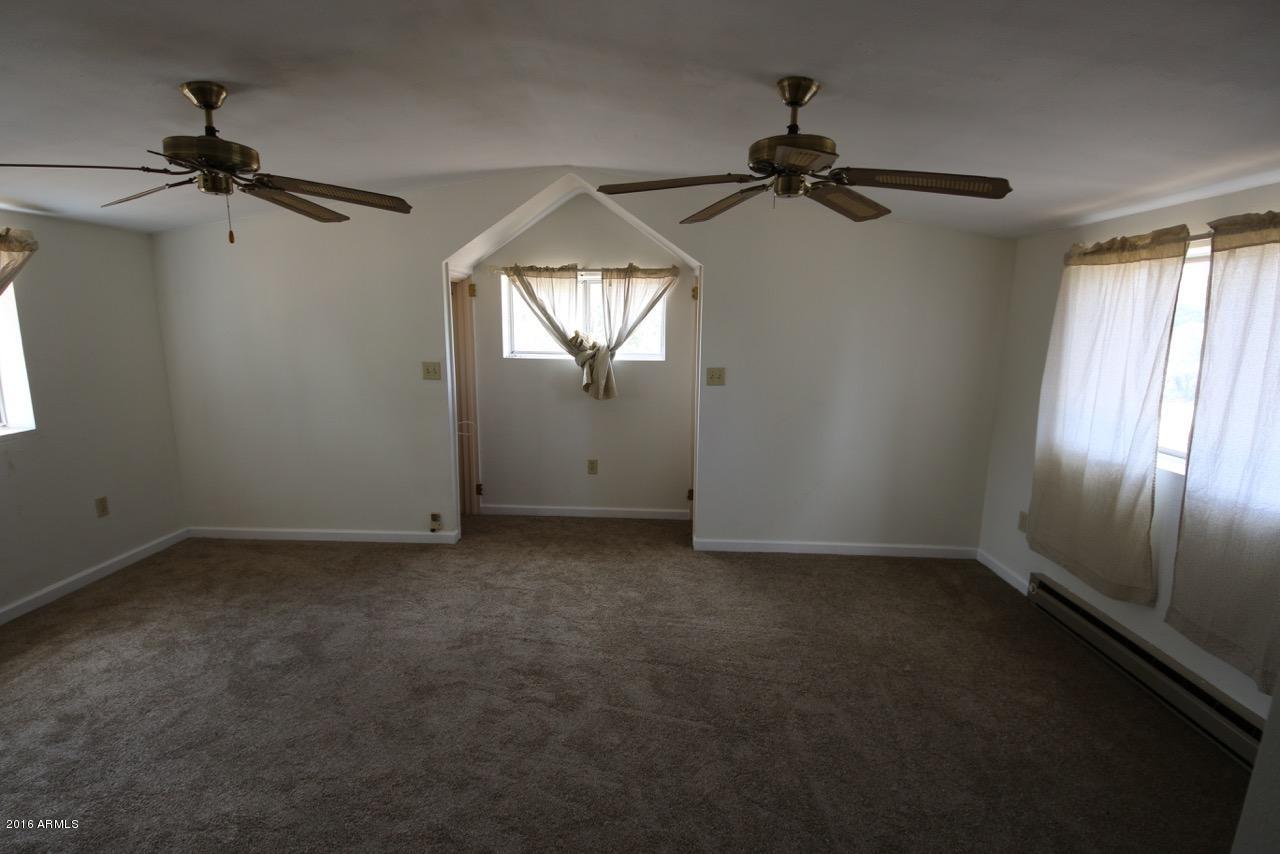3070 Aspen Road Overgaard, AZ 85933 - Photo 33 of 38 an empty room with a window and a fan