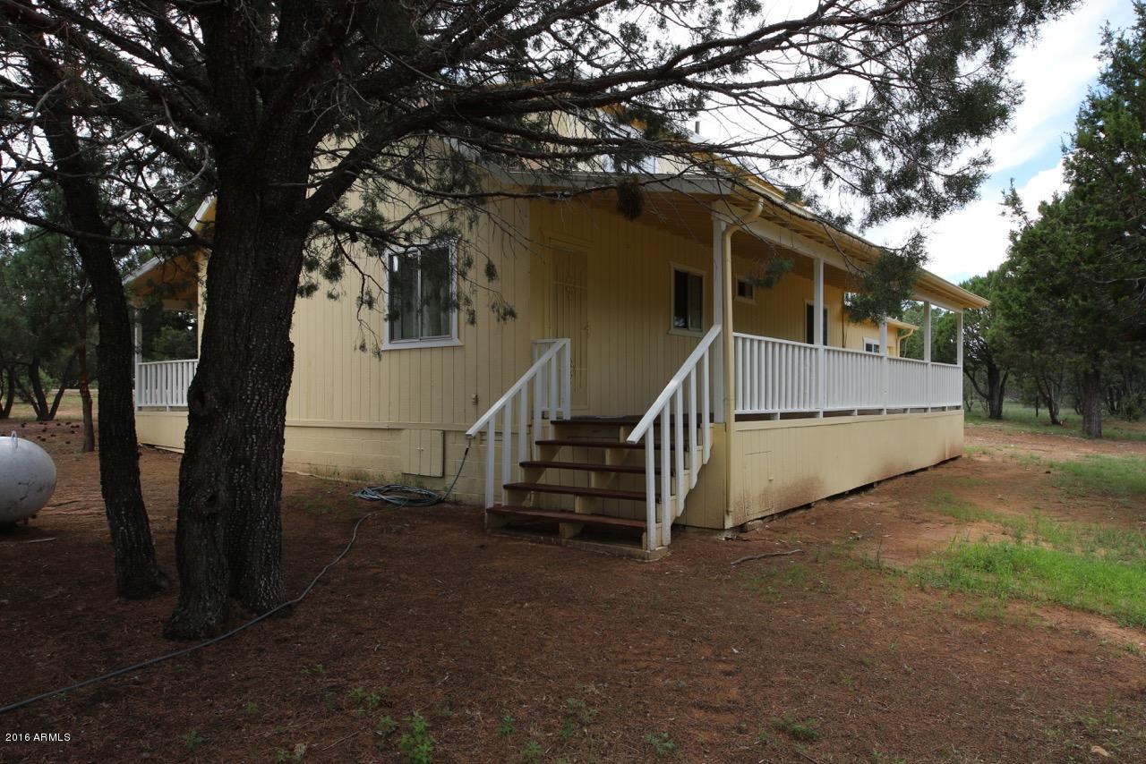 3070 Aspen Road Overgaard, AZ 85933 - Photo 9 of 38 a view of house with large tree and wooden fence