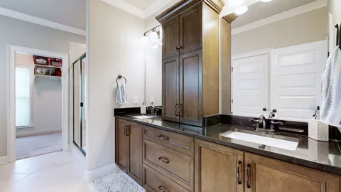 a bathroom with a granite countertop double vanity sink and a mirror
