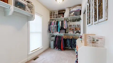 a view of walk in closet with clothes and shoes